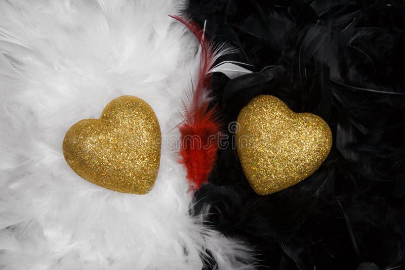 Two hearts over white and black feathers backgroun