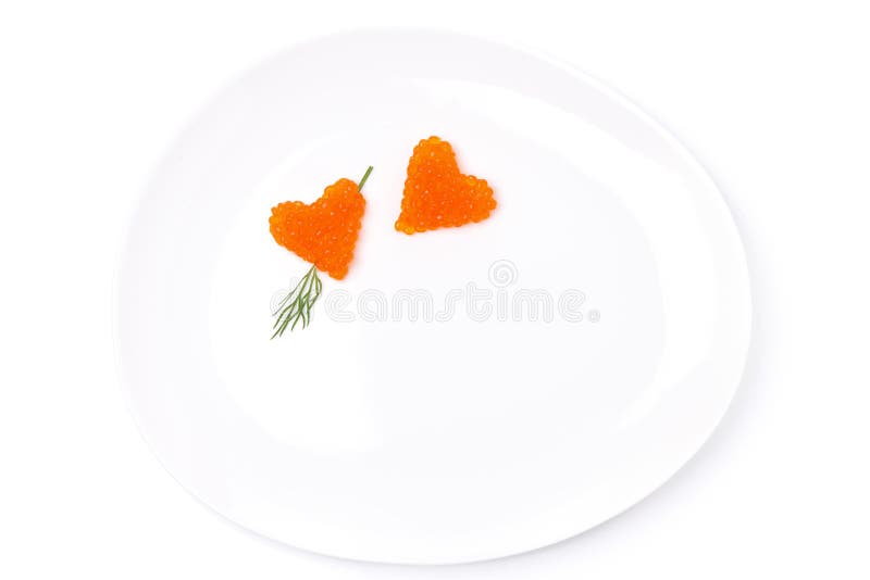 Two hearts of red caviar with dill on a plate, isolated