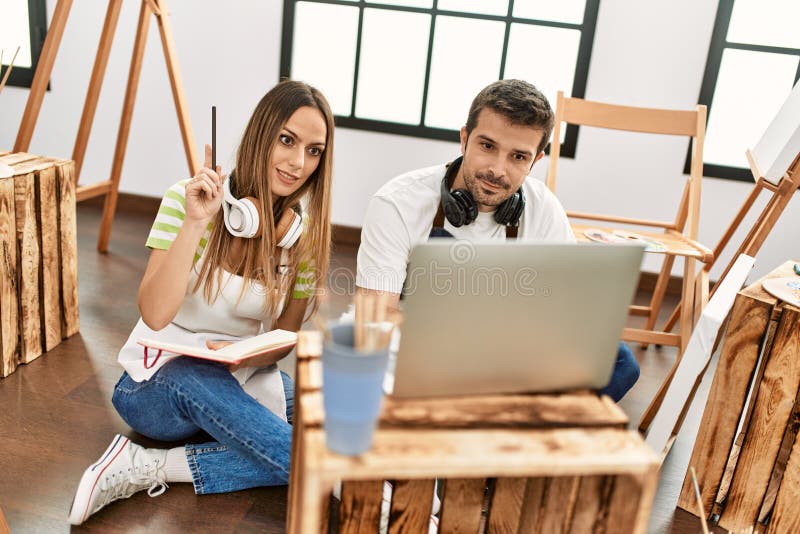 Two Hispanic Students Having Online Paint Class Using Laptop at Art