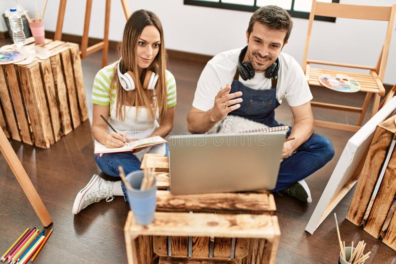 Two Hispanic Students Having Online Paint Class Using Laptop at Art