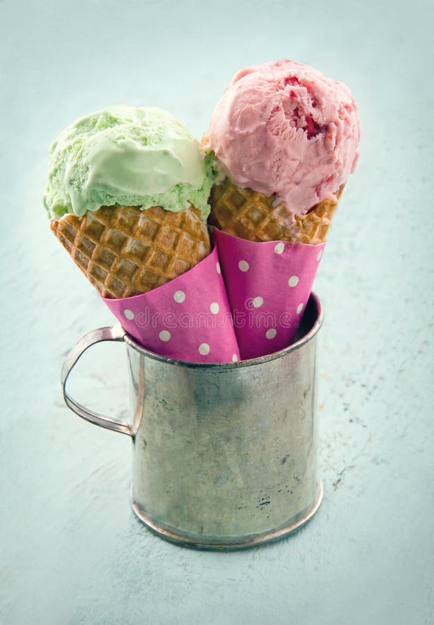 Two ice cream cones in an old metal mug on blue shabby chic vintage background