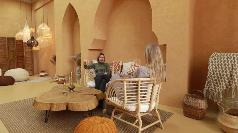 Relaxing conversation in a cozy, modern interior decorated with natural elements and warm colors stock footage