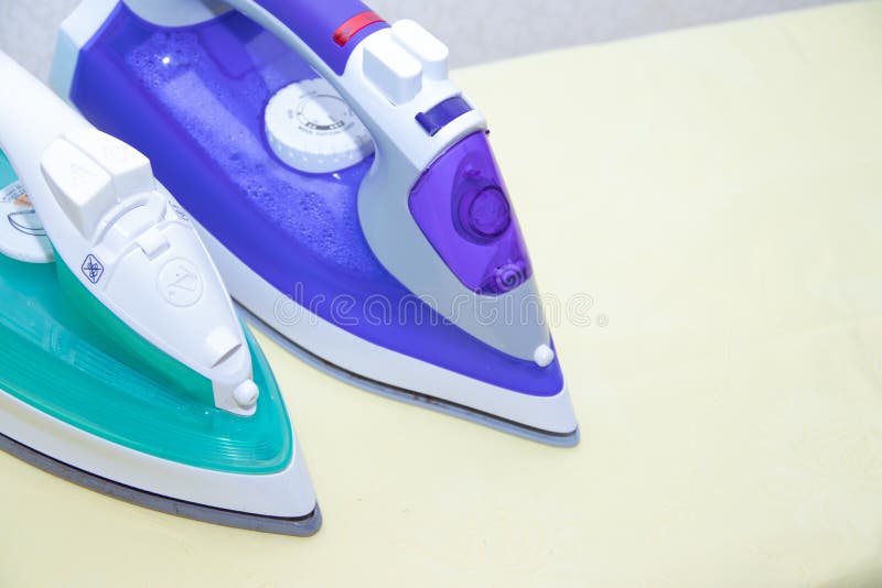 Two Irons on an Ironing Board. Selection and Comparison of Irons. Ironing Board Stock Image