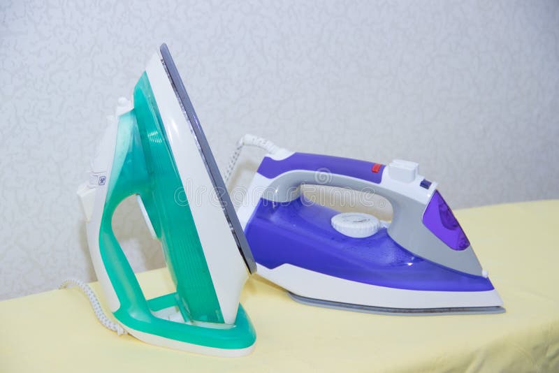 Two Irons on an Ironing Board. Selection and Comparison of Irons. Ironing Board Stock Image