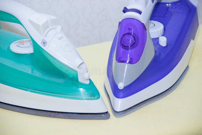 Two Irons on an Ironing Board. Selection and Comparison of Irons. Ironing Board Stock Image