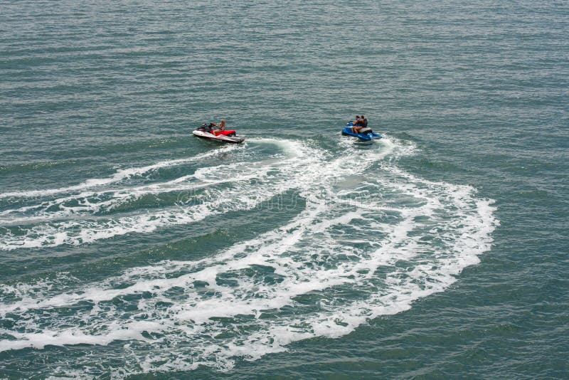 Two jet skis or personal watercraft speeding across the ocean