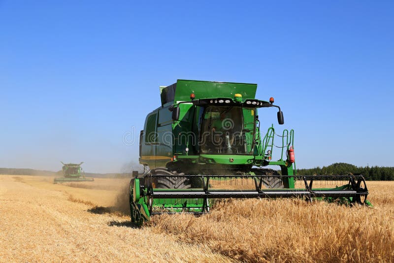 Two John Deere Combines Harvest Barley stock photos Two John Deere Combines Harvest Barley stock photos