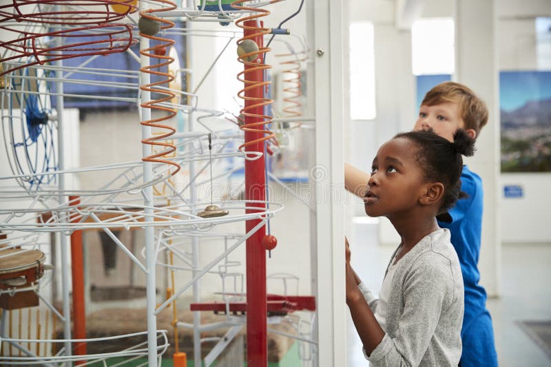 Two kids looking at a science exhibit, waist up stock images Two kids looking at a science exhibit, waist up stock images