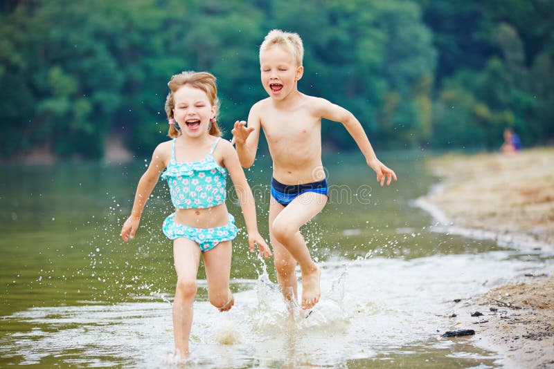 Two kids running through sea water