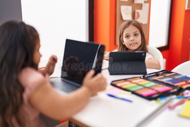 Two Kids Students Using Laptop and Touchpad Studying at Classroom Stock