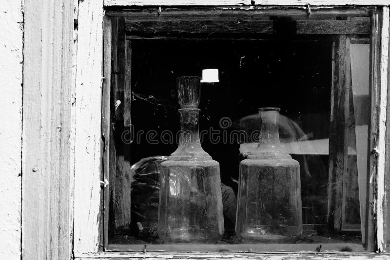 Two Kitchen Glassware in the Window of an Old Village House Stock Photo