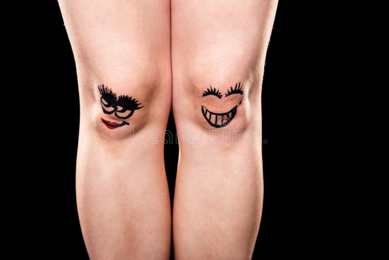 Two Knees with Funny Faces in Front of Yellow Background Stock Image