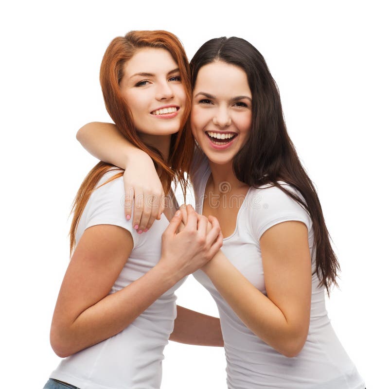 Two laughing girls in white t-shirts hugging