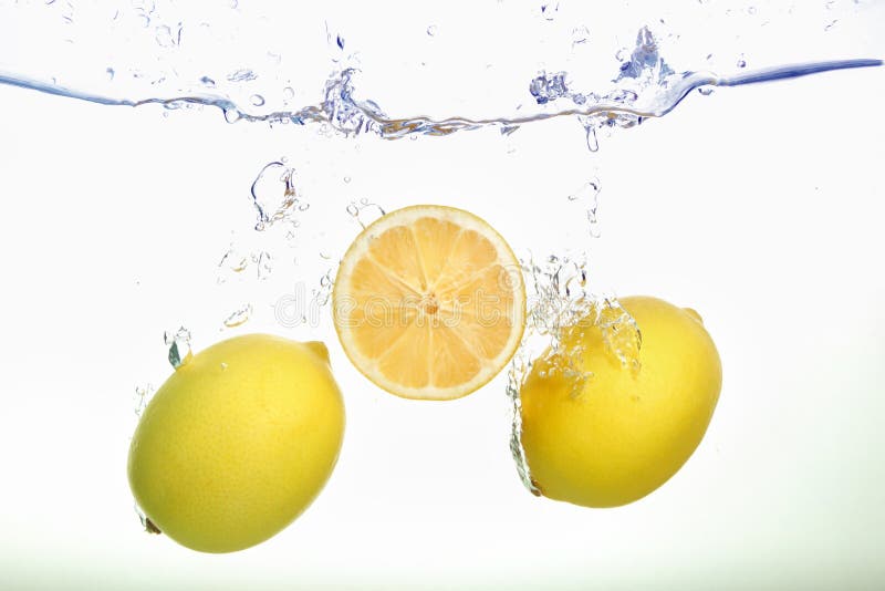 Two lemons and lemon slice spash in water on white background