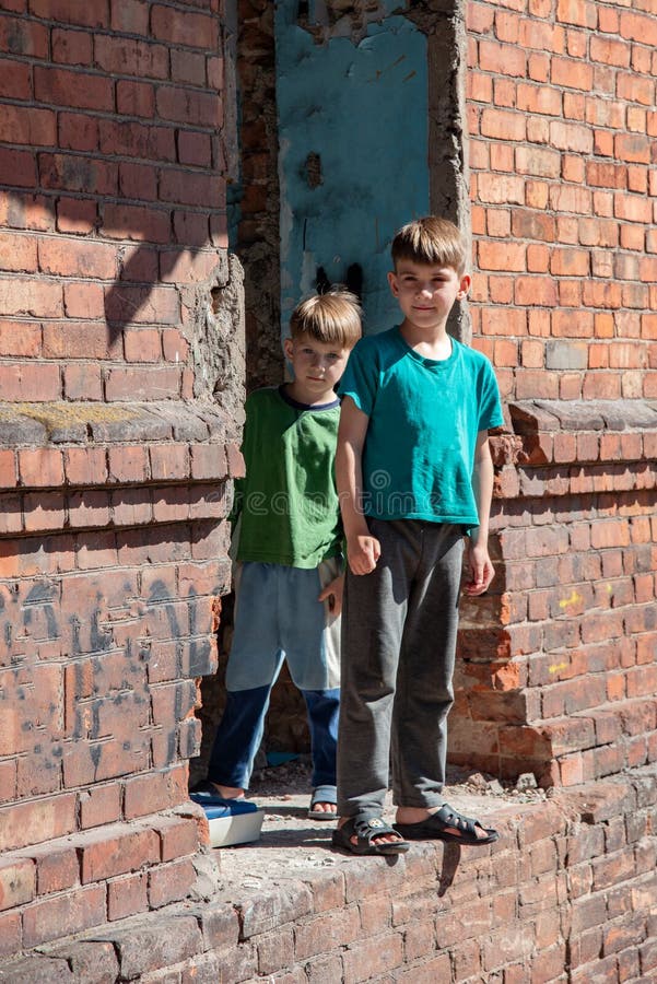 Two little brothers are orphans, living in an abandoned and abandoned house, children of war. Staged photo stock photography Two little brothers are orphans, living in an abandoned and abandoned house, children of war. Staged photo stock photography