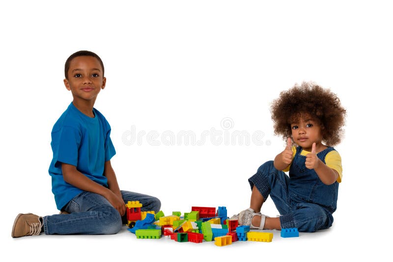 Two little cute african american children playing on the floor with lots of colorful plastic blocks, isolated on white