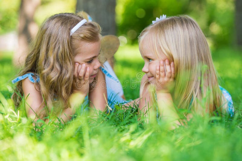 Two Little Cute Girls Lying on Lawn Stock Image - Image of happy ...