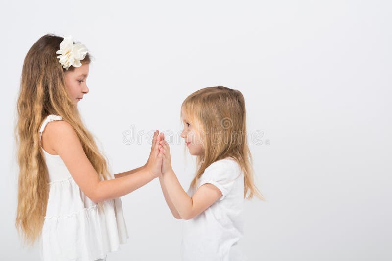 Two little girls dressed in white playing stock images