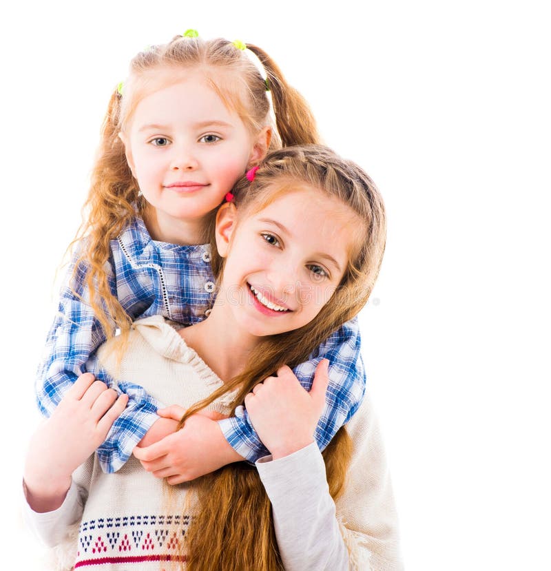 Little girl sisters. Две сестры разного возраста. 2 Маленькие девочки в костюмах России и Украины обнимают друг друга. Clothes hugging. Half-length photo of two girls wearing Graduation clothes hugging.