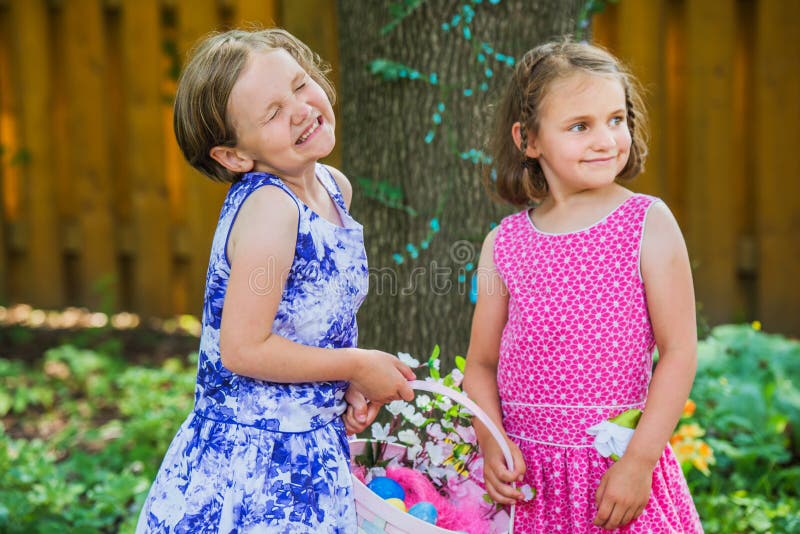 Two Little Girls Smiling and Holding an Easter Basket