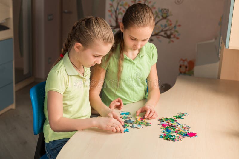 Two little girls solving puzzle together royalty free stock photo Two little girls solving puzzle together royalty free stock photo