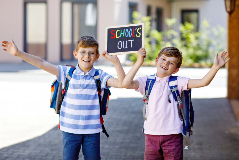 Two little kid boys with backpack or satchel. Schoolkids on the way to school. Healthy children, brothers and best