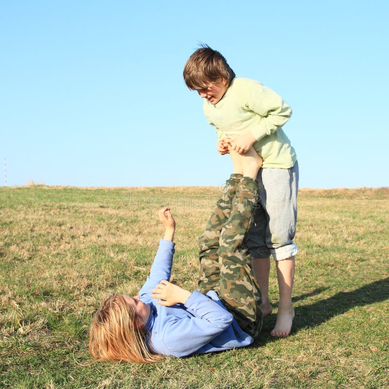 Two kids playing and exercising yoga on meadow stock photos Two kids playing and exercising yoga on meadow stock photos