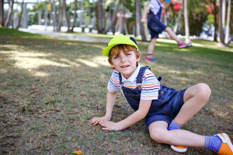 Two little kids boys having fun in a park, happy best friends playing, friendship concept. Siblings brothers, twins in stock photos Two little kids boys having fun in a park, happy best friends playing, friendship concept. Siblings brothers, twins in stock photos