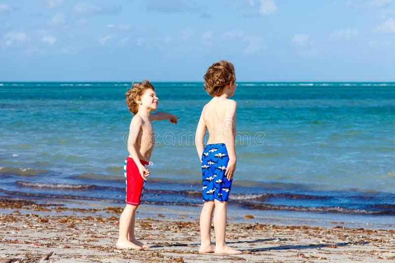 Two little kids boys having fun on tropical beach