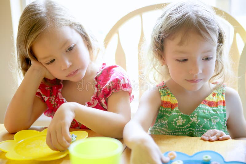 Two little sister girls eating together stock photos Two little sister girls eating together stock photos