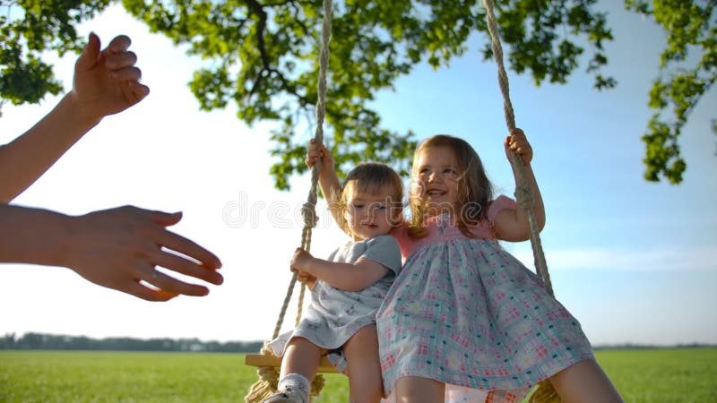 Two Red Headed Sisters Sharing A Rope Tree Swing by Stocksy