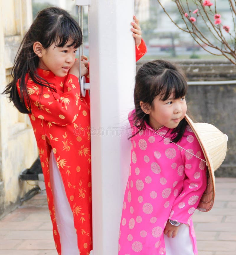 Two little Vietnamese girls play and laugh in national costumes stock image Two little Vietnamese girls play and laugh in national costumes stock image