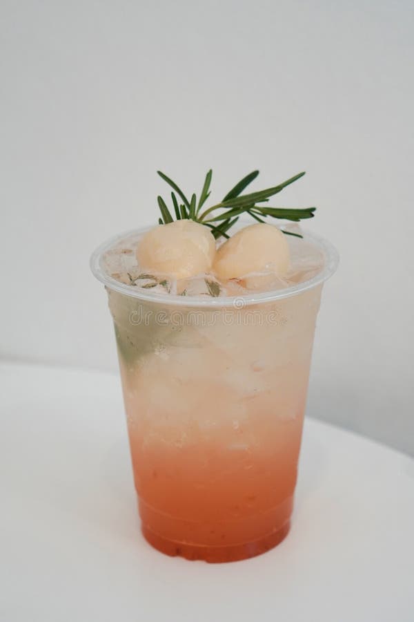 Two Lychee Soda and Green Leaves in a Plastic Cup, on a White Background, Fruit, Drink, Nature