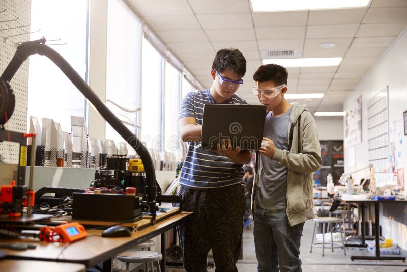 Two Male College Students Using Laptop Computer In Science Robotics Or Engineering Class stock photo