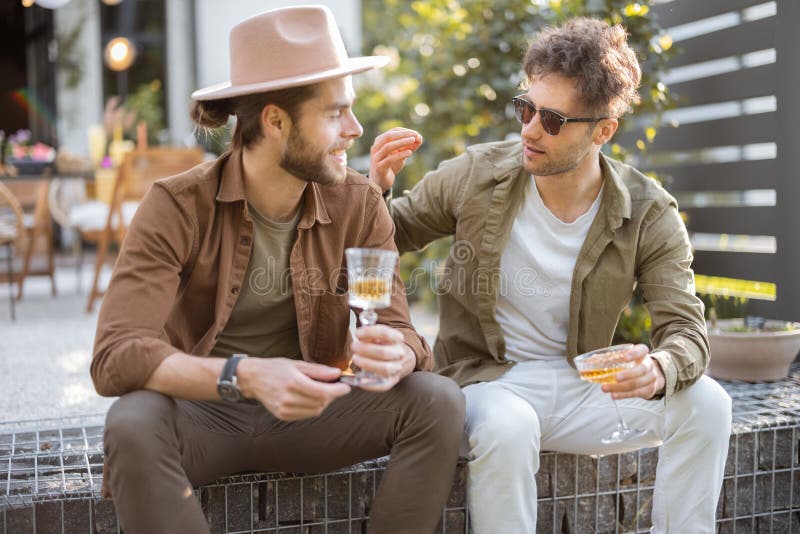 Two male friends talking on a porch of the country house