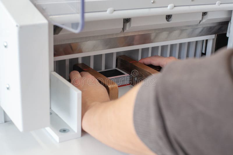 Two Man Hands Align a Stack of Business Cards or Tags with Wooden Pushers in an Automatic Paper