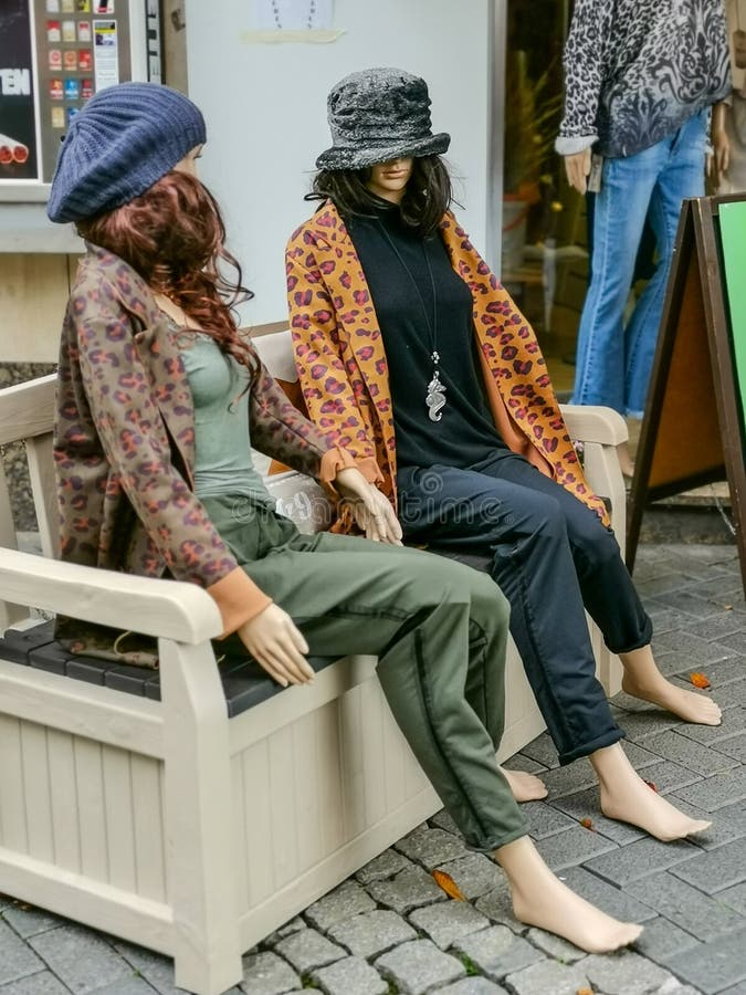 Two Mannequins Display Dummy Sitting on a White Bench Stock Photo
