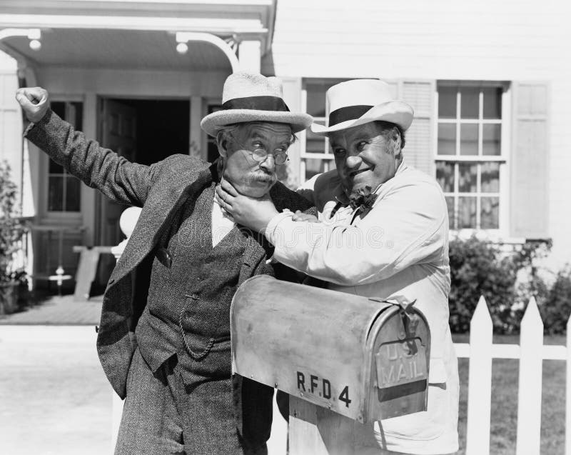 Two mature men fighting near a mail box in front of a house