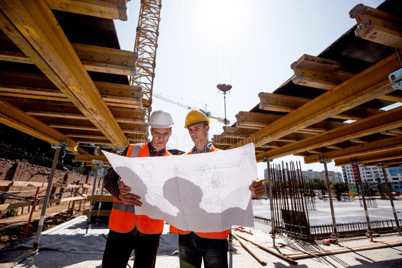 Two Men Dressed in Shirts, Orange Work Vests and Helmets Explore