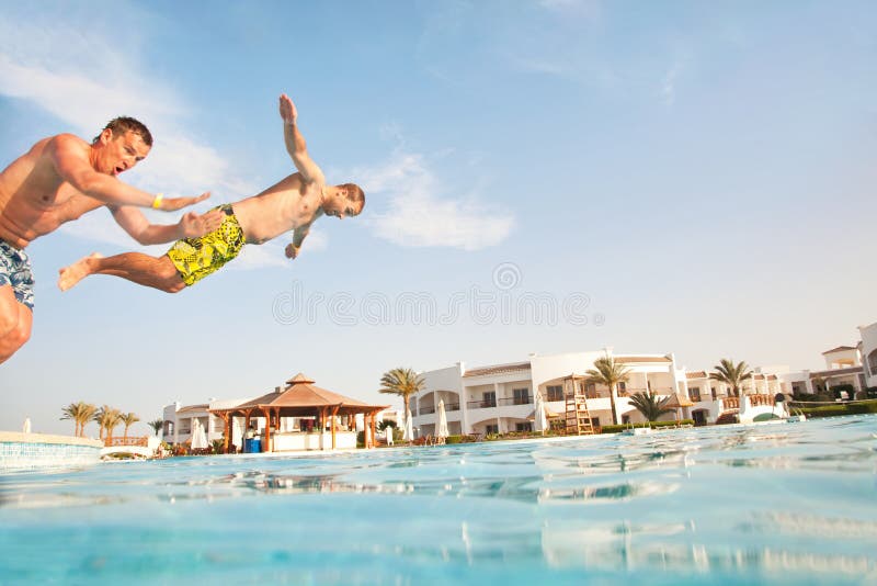 Two men having fun at swimming pool. royalty free stock photo