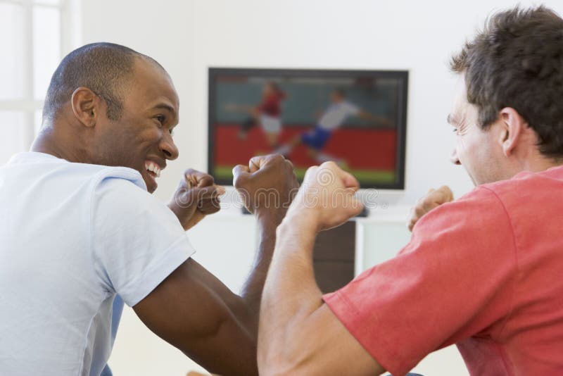 Two men in living room watching television