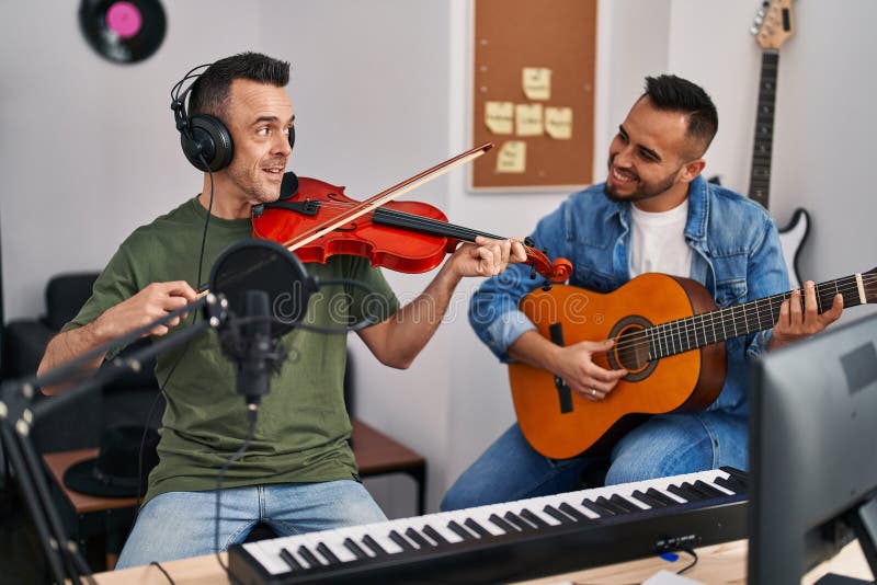 Two Men Musicians Playing Classical Guitar and Violin at Music Studio