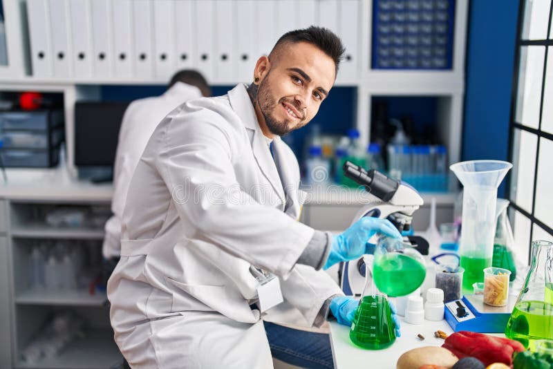 Two Men Scientists Pouring Liquid on Test Tube at Laboratory Stock