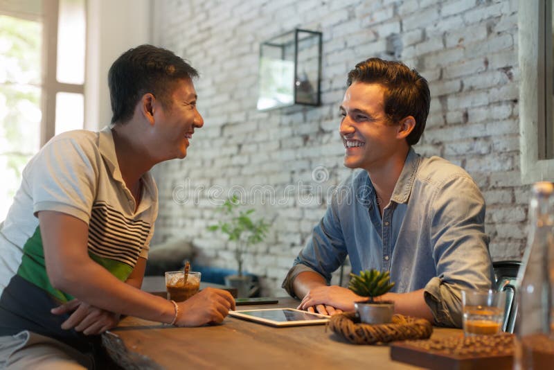 Two Men Sitting At Cafe Asian Mix Race Friends Stock