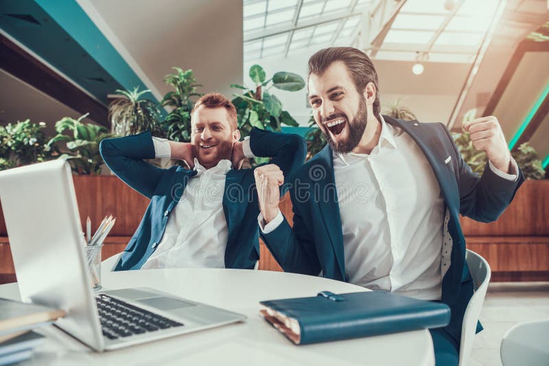 two-men-suits-celebrating-looking-laptop-office-119238510.jpg