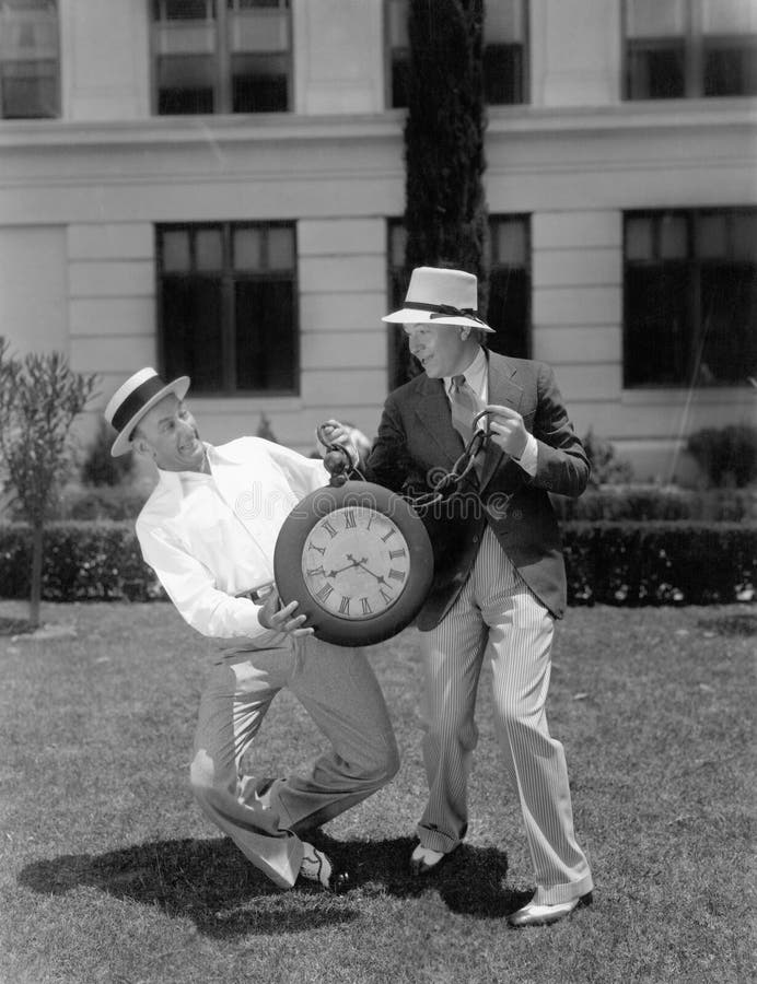 Two men wrestling with an oversized pocket watch royalty free stock photo Two men wrestling with an oversized pocket watch royalty free stock photo