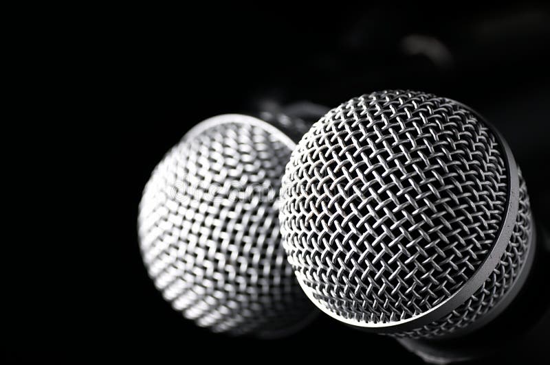 Two microphones on a black background.