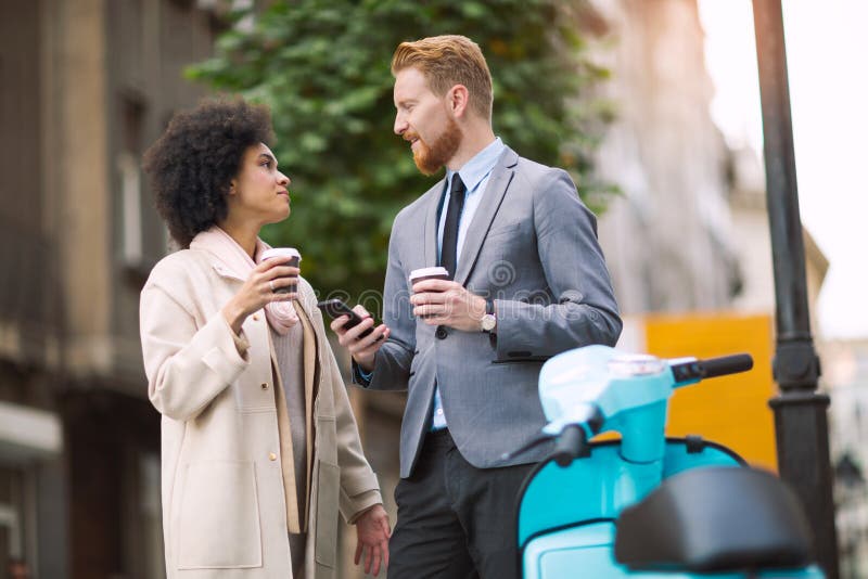 Two mixed race business people talking outside company