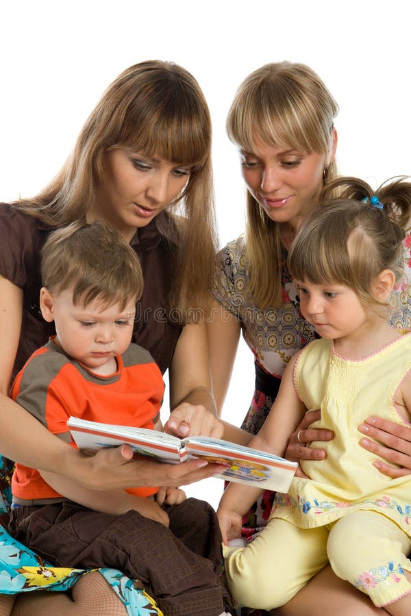 Two mothers read books to their children stock images