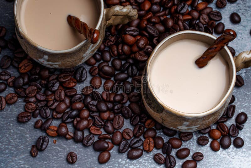 Two Mugs of Coffee with Coffee Beans on a Dark Backdrop Stock Image